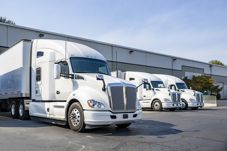 Tractor-trailers parked at a warehouse loading area